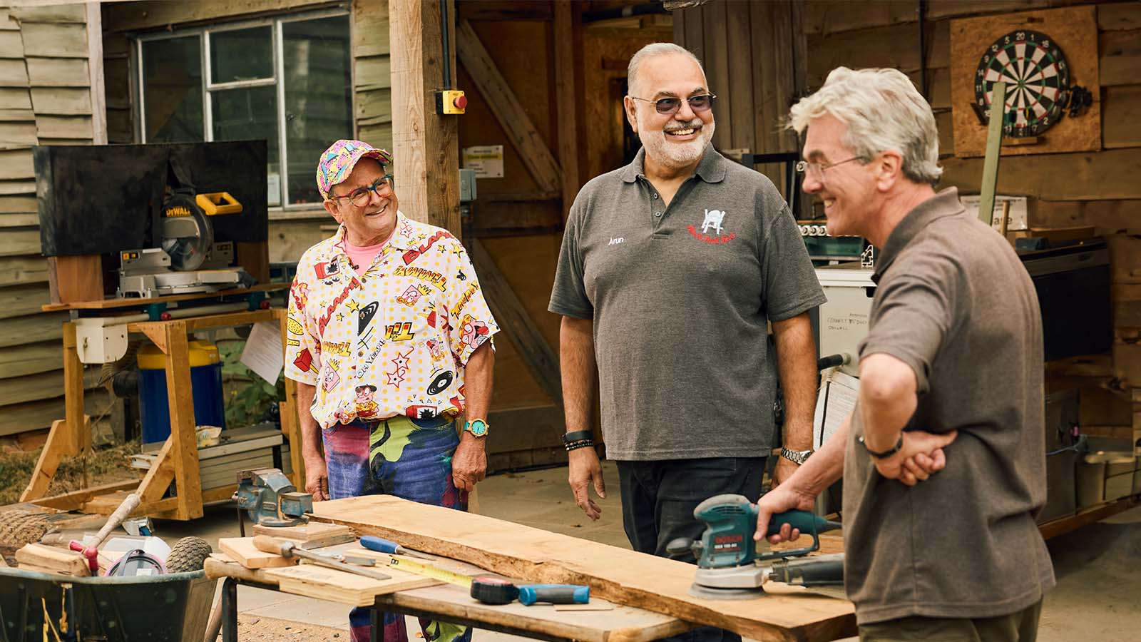 three men standing at carpenter workshop